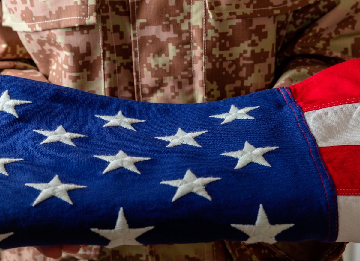 Folded American flag with white stars on blue field.
