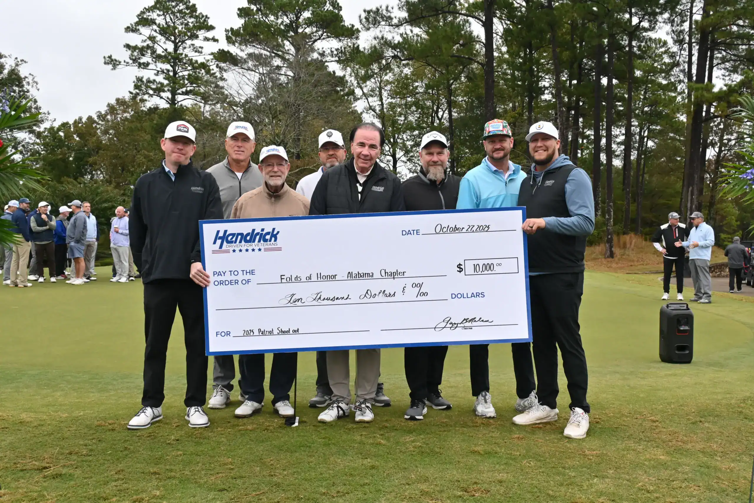Hendrick Driven for Veterans supporters present a charitable donation check at a golf event.